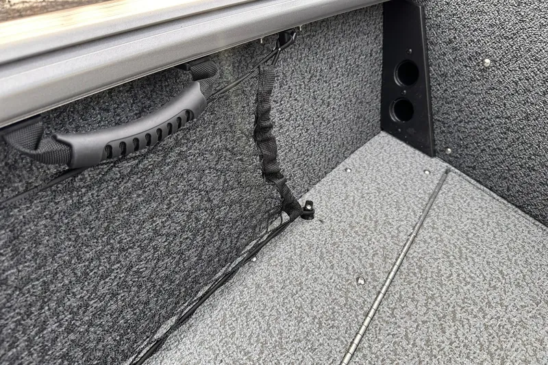 Slide: The Image of 2026 Lund 1875 Impact XS Sport interior with textured flooring and storage handle. - 18