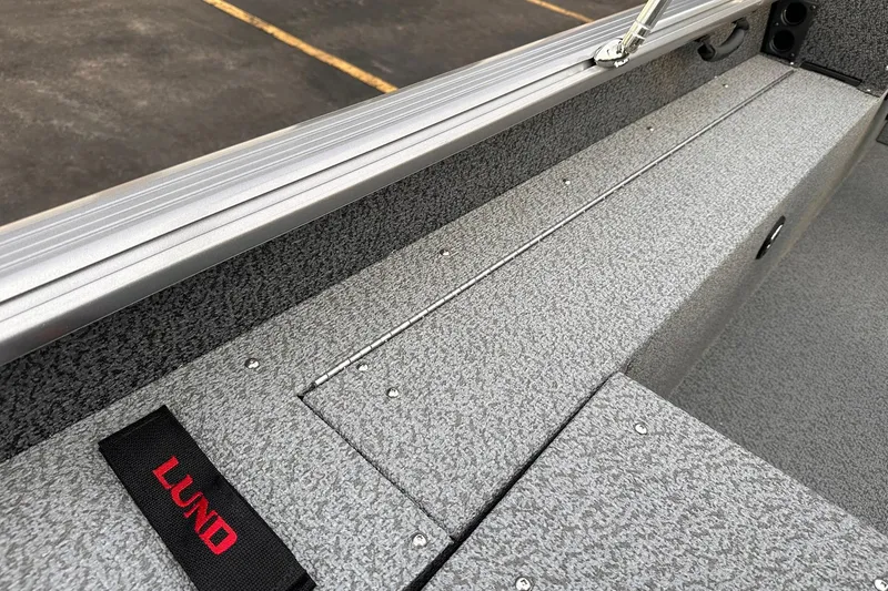 Slide: The Image of 2026 Lund 1875 Impact XS Sport boat interior with textured gray finish and branded strap. - 20
