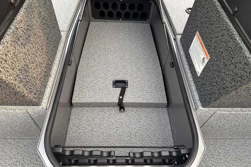 Slide: The Image of 2026 Lund 1875 Impact XS Sport boat interior storage compartment with gray carpet. - 23