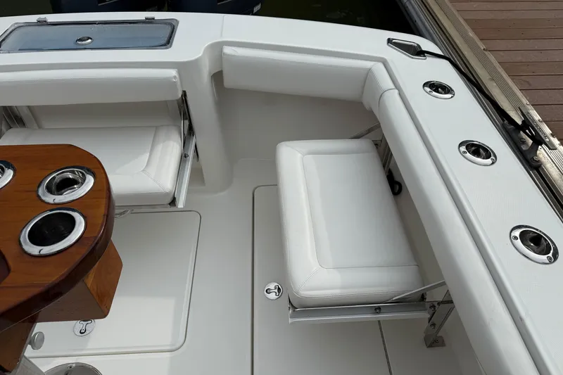 Slide: The Image of 2020 Albemarle 290 Express Fisherman boat interior with white seating and wooden table. - 12