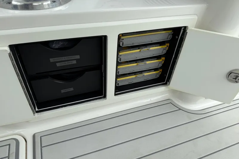 Slide: The Image of 2020 Albemarle 290 Express Fisherman storage compartments with organized tackle boxes and drawers. - 22