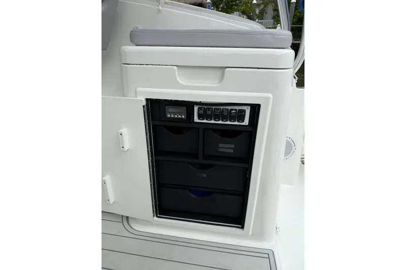 Slide: The Image of 2020 Albemarle 290 Express Fisherman boat storage compartment with control panel and drawers. - 23