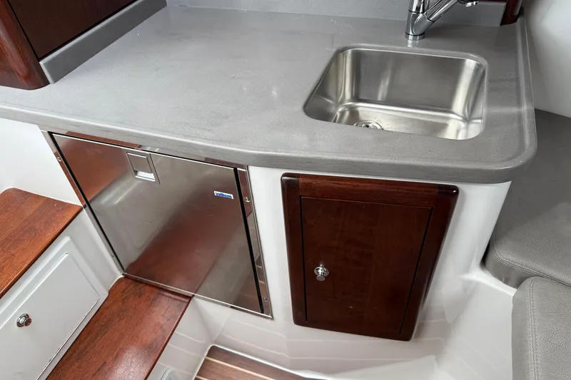 Slide: The Image of 2020 Albemarle 290 Express Fisherman interior with sink, stainless fridge, and wooden cabinetry. - 37