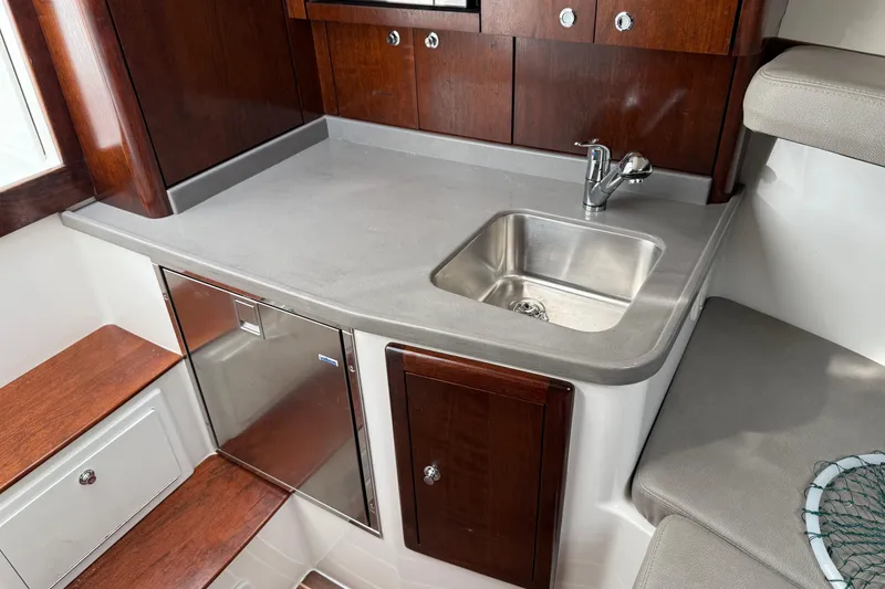 Slide: The Image of 2020 Albemarle 290 Express Fisherman interior with sink, countertop, and wooden cabinetry. - 38