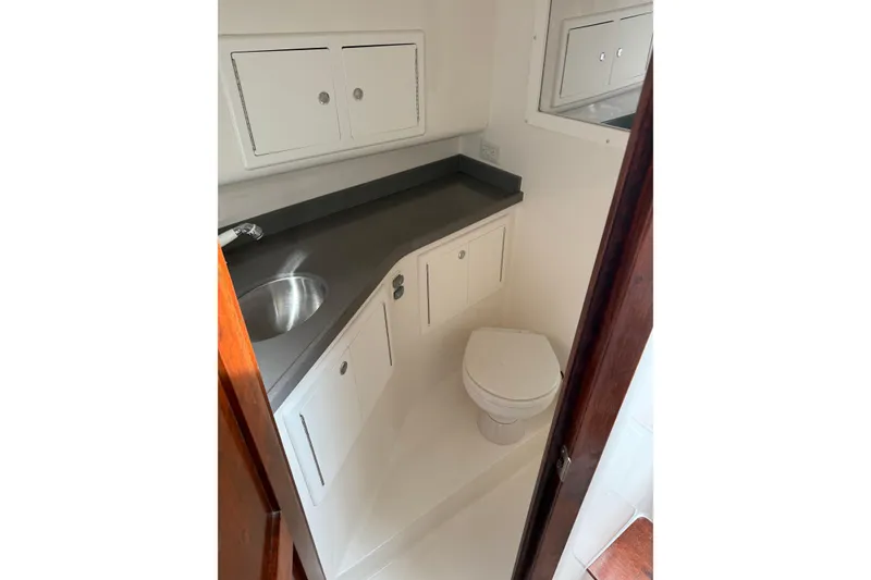 Slide: The Image of 2020 Albemarle 290 Express Fisherman boat bathroom with sink, toilet, and storage cabinets. - 42