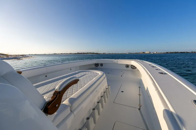 Slide: The Image of 2024 Freeman 47 boat on calm water, featuring spacious deck and seating. - 24