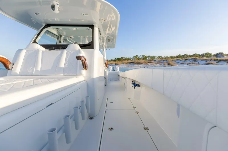 Slide: The Image of 2024 Freeman 47 boat interior with white seating and rod holders, set against a coastal backdrop. - 28