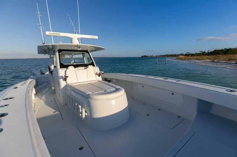 Slide: The Image of 2024 Freeman 47 boat on calm waters near a sandy shoreline under a clear blue sky. - 5
