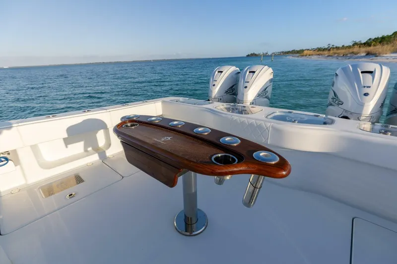 Slide: The Image of 2024 Freeman 47 boat with wooden rod holder, ocean view, and powerful outboard engines. - 9