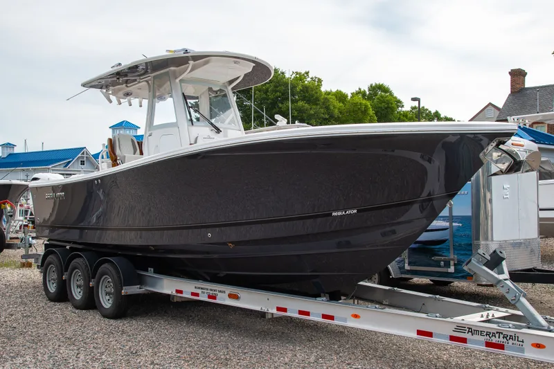 The Image of A 2027 Regulator 28 boat on a trailer, surrounded by buildings and trees. - 0