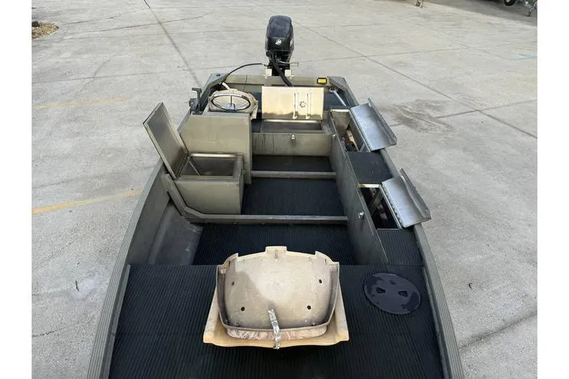 Slide: The Image of 2012 Gator Trax 17X54 boat interior with seating and motor, parked on concrete. - 9
