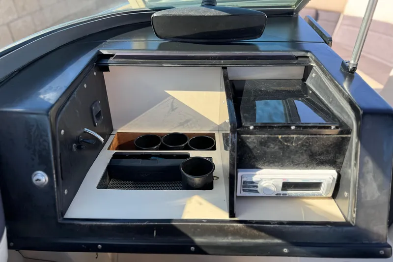 Slide: The Image of 1988 Cobalt 222 boat dashboard with cup holders and stereo system. - 19