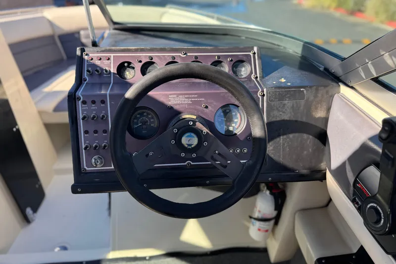Slide: The Image of Steering wheel and dashboard of a 1988 Cobalt 222 boat, featuring gauges and controls. - 22