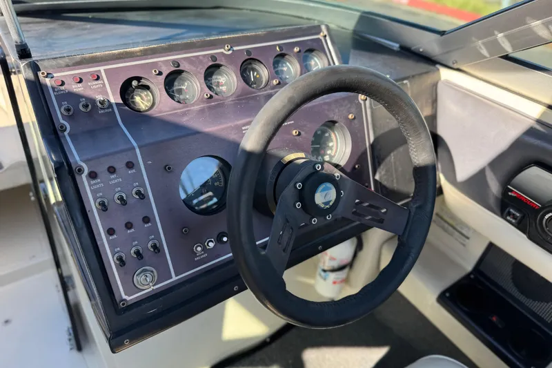 Slide: The Image of 1988 Cobalt 222 boat dashboard with steering wheel and control panel. - 23