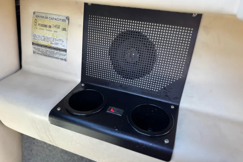 Slide: The Image of 1988 Cobalt 222 boat interior with speaker, cup holders, and capacity label. - 24