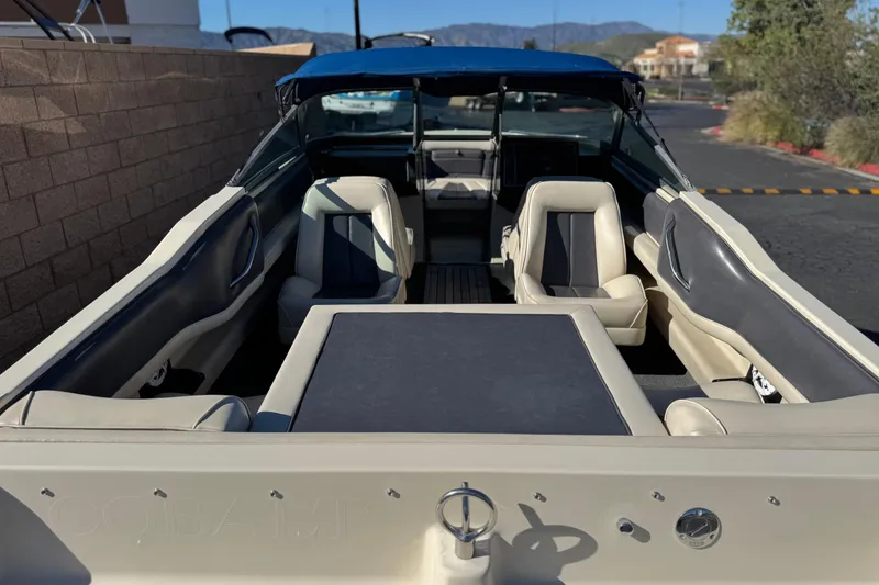 Slide: The Image of 1988 Cobalt 222 boat interior with beige and navy seating, parked outdoors. - 8