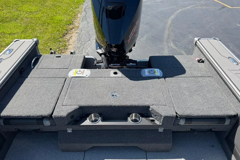 Slide: The Image of 2026 Lund 1875 Pro-V boat interior with motor, featuring spacious deck and storage compartments. - 12