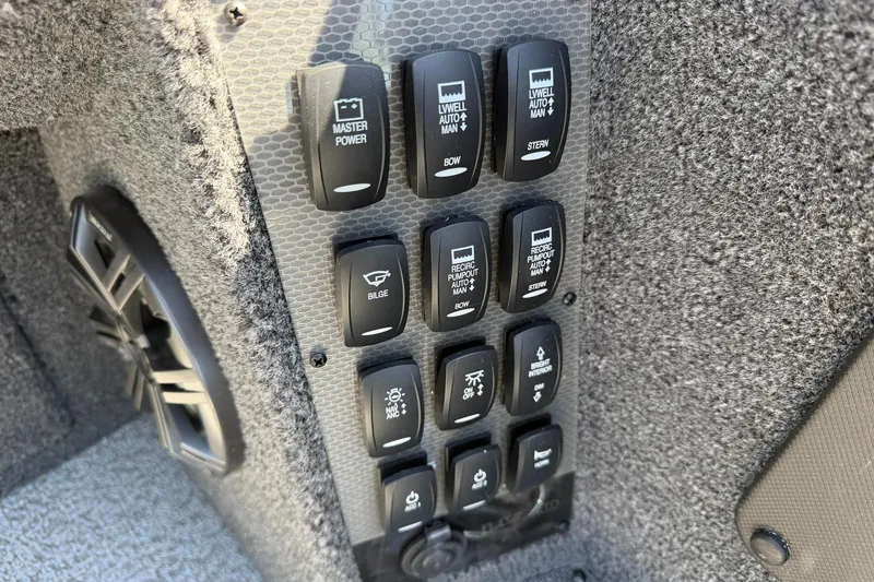 Slide: The Image of Control panel of 2026 Lund 1875 Pro-V boat with various switches and speaker. - 15