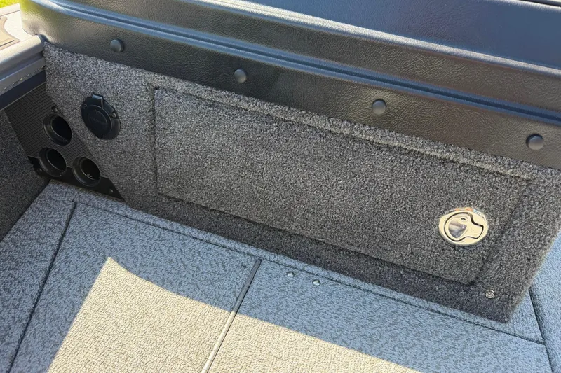 Slide: The Image of Interior of 2026 Lund 1875 Pro-V boat showing storage compartment and outlets. - 23