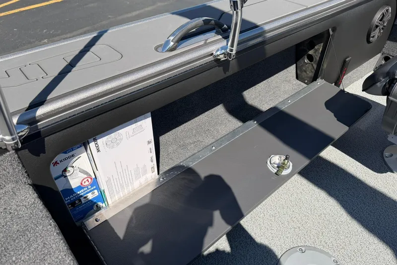 Slide: The Image of Interior of 2026 Lund 1875 Pro-V boat showing storage compartment and safety equipment. - 26