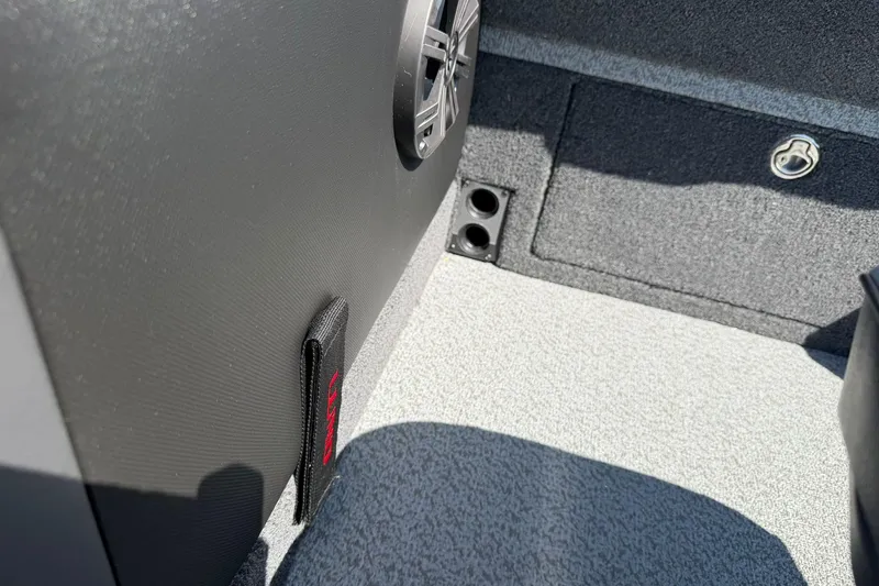 Slide: The Image of Interior detail of 2026 Lund 1875 Pro-V boat, featuring speaker and storage compartment. - 29