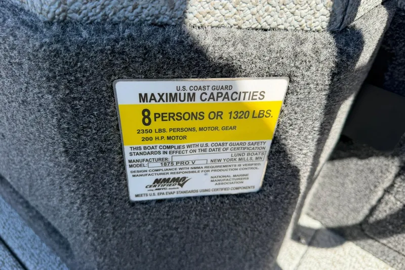 Slide: The Image of U.S. Coast Guard capacity label on 2026 Lund 1875 Pro-V boat, 8 persons or 1320 lbs. - 32