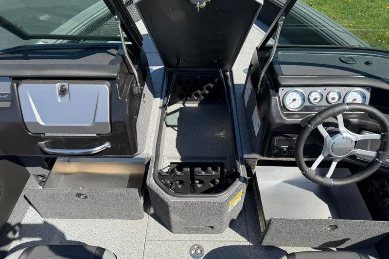 Slide: The Image of 2026 Lund 1875 Pro-V boat interior with open storage compartments and steering wheel. - 9