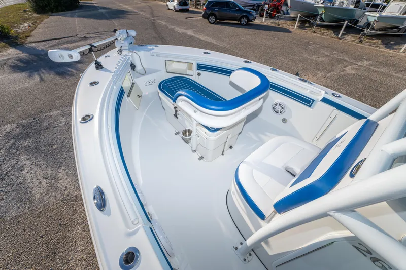 Slide: The Image of 2017 Crevalle 26 Open boat interior with blue and white seating, docked on pavement. - 15