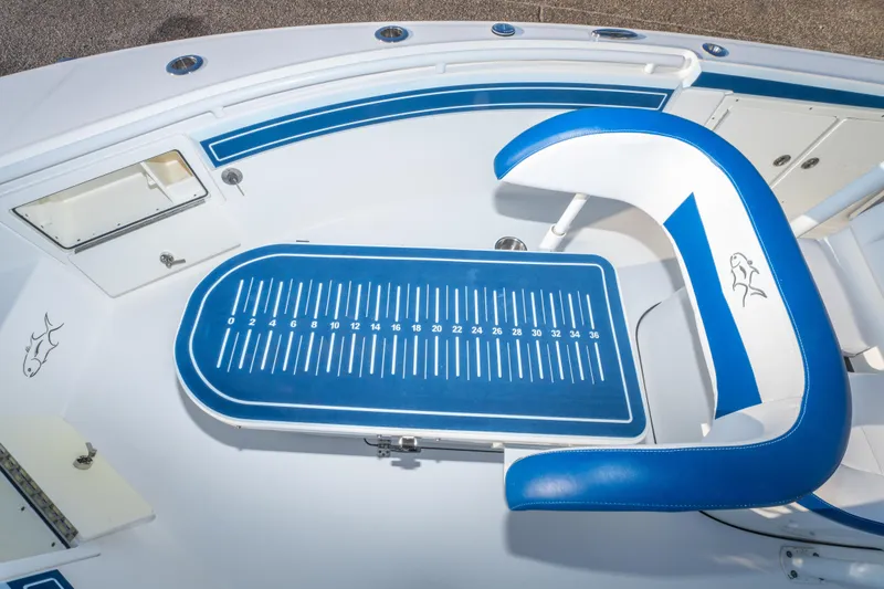 Slide: The Image of 2017 Crevalle 26 Open boat interior with blue and white seating and measuring board. - 16