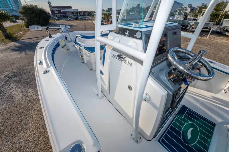 Slide: The Image of 2017 Crevalle 26 Open boat interior with steering wheel and console, docked outdoors. - 27