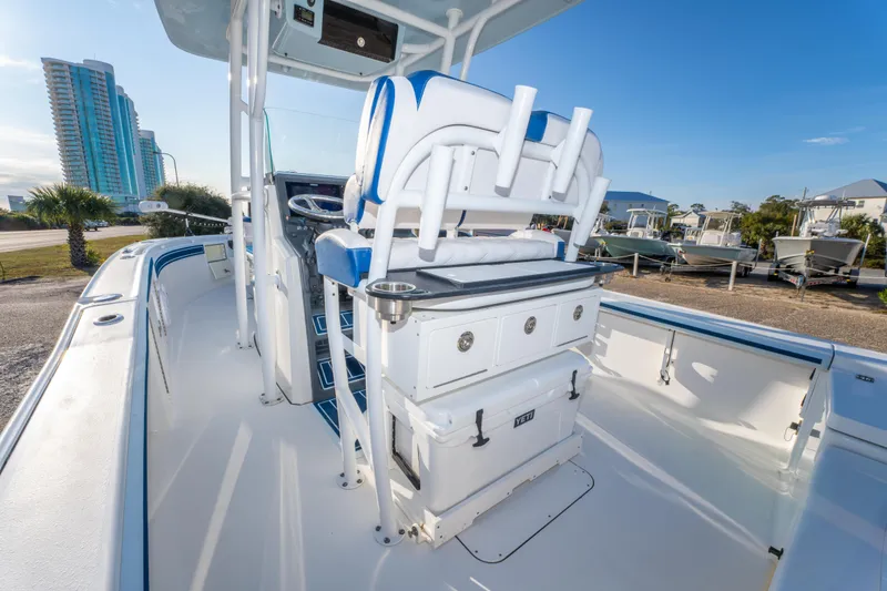 Slide: The Image of 2017 Crevalle 26 Open boat interior with helm, seating, and storage, docked near buildings. - 32