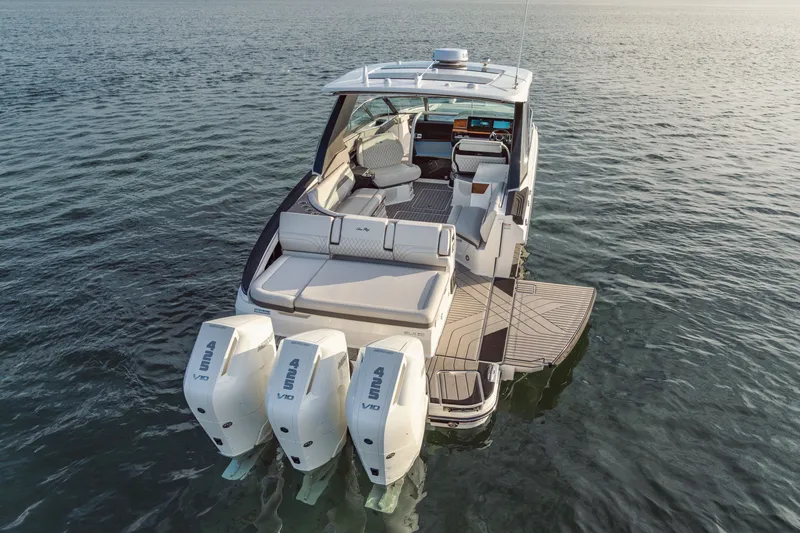 Slide: The Image of A 2027 Sea Ray SLX 360 Outboard on calm water. Three outboard engines and a spacious deck are visible. - 1