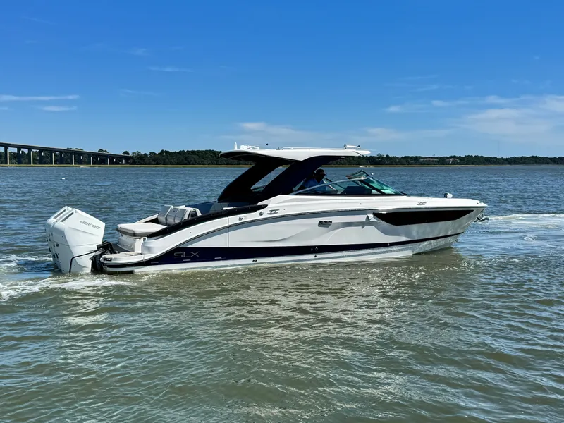 Slide: The Image of A 2027 Sea Ray SLX 360 Outboard cruising on calm water. The sky is clear and blue. - 27
