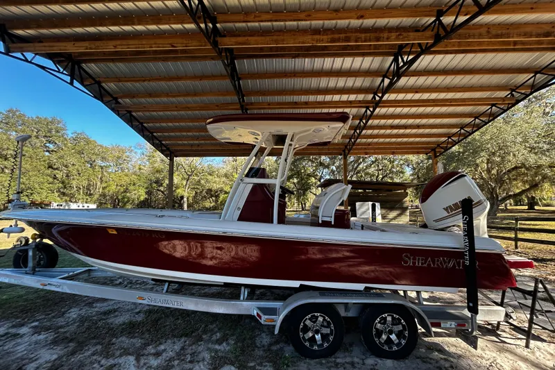 Slide: The Image of 2017 ShearWater 260 Carolina Bay boat under a metal canopy, on a trailer. - 3