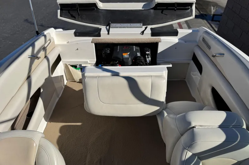 Slide: The Image of 2005 Chaparral 210 SSi boat interior with open engine compartment and beige seating. - 22