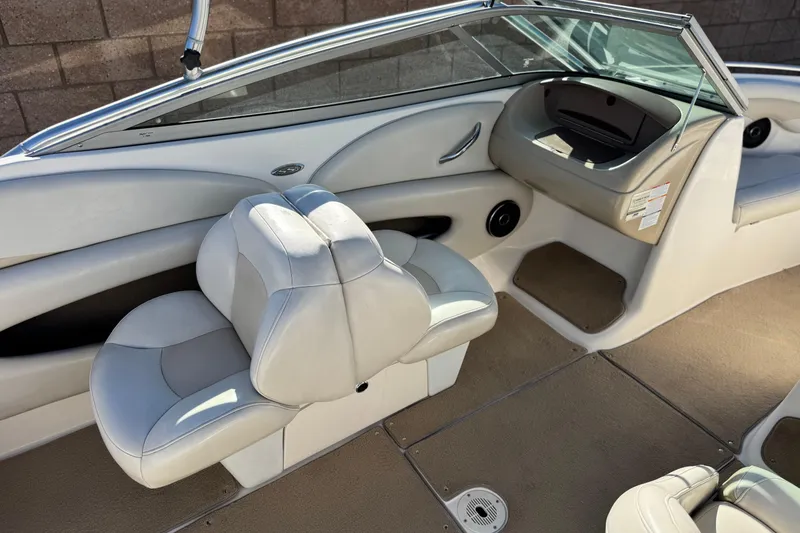 Slide: The Image of 2005 Chaparral 210 SSi boat interior with beige seating and carpeted flooring. - 25