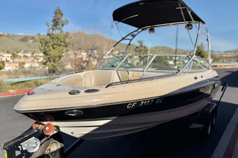 Slide: The Image of 2005 Chaparral 210 SSi boat on trailer, parked outdoors with scenic background. - 3