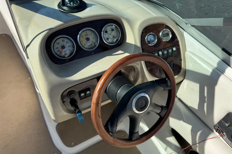 Slide: The Image of 2005 Chaparral 210 SSi boat dashboard with gauges and wooden steering wheel. - 33