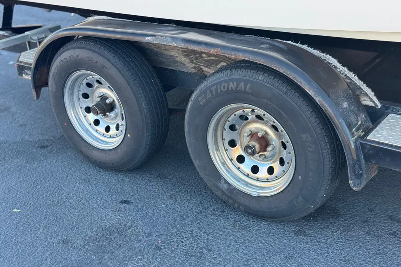 Slide: The Image of Trailer wheels of a 2005 Chaparral 210 SSi boat on asphalt surface. - 34