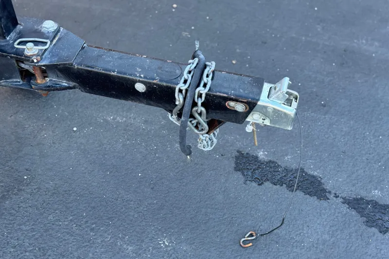Slide: The Image of Trailer hitch of a 2005 Chaparral 210 SSi with safety chains and lock mechanism. - 35