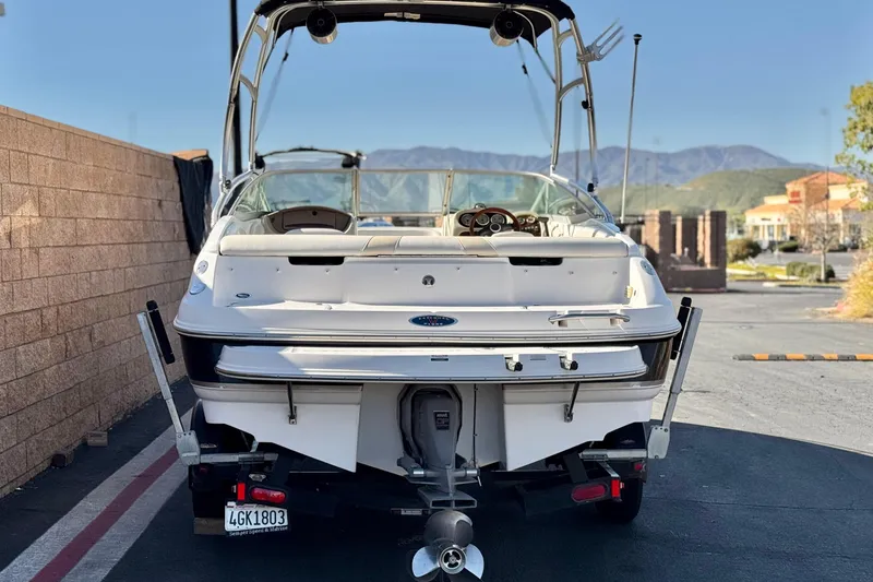 Slide: The Image of 2005 Chaparral 210 SSi boat, rear view, parked outdoors with mountains in background. - 4