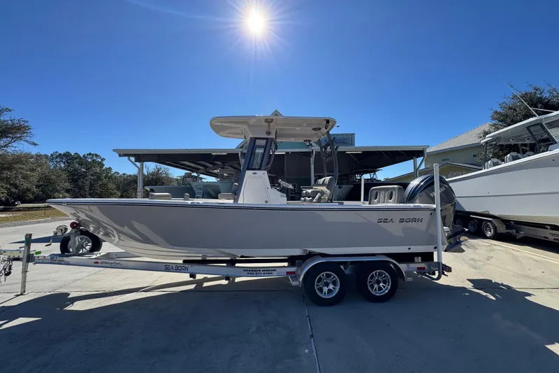 The Image of 2026 Sea Born LX24 Center Console boat on trailer under sunny sky. - 1
