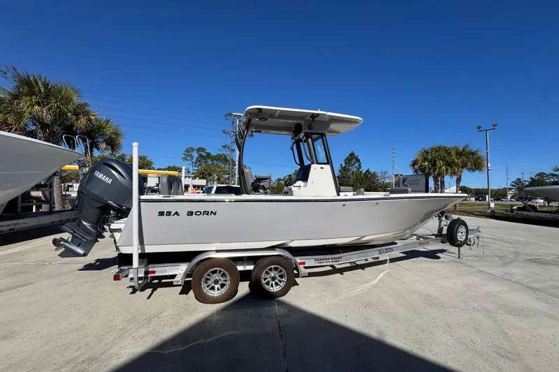 Slide: The Image of 2026 Sea Born LX24 Center Console boat on trailer, parked outdoors under clear blue sky. - 10