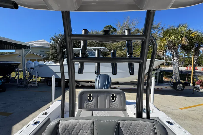 Slide: The Image of 2026 Sea Born LX24 Center Console boat with rod holders, parked outdoors. - 28