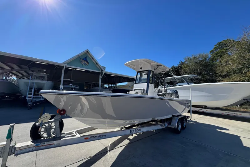Slide: The Image of 2026 Sea Born LX24 Center Console boat on trailer under clear blue sky. - 3