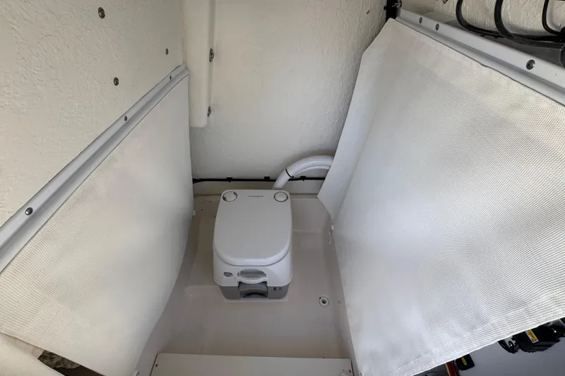 Slide: The Image of 2026 Sea Born LX24 Center Console boat interior with portable toilet setup. - 39