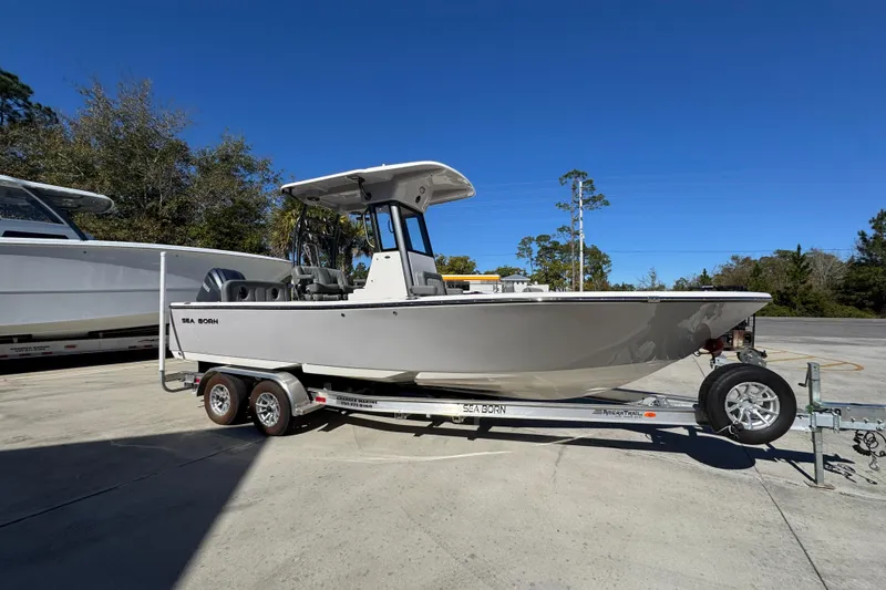 Slide: The Image of 2026 Sea Born LX24 Center Console boat on trailer, parked outdoors. - 8
