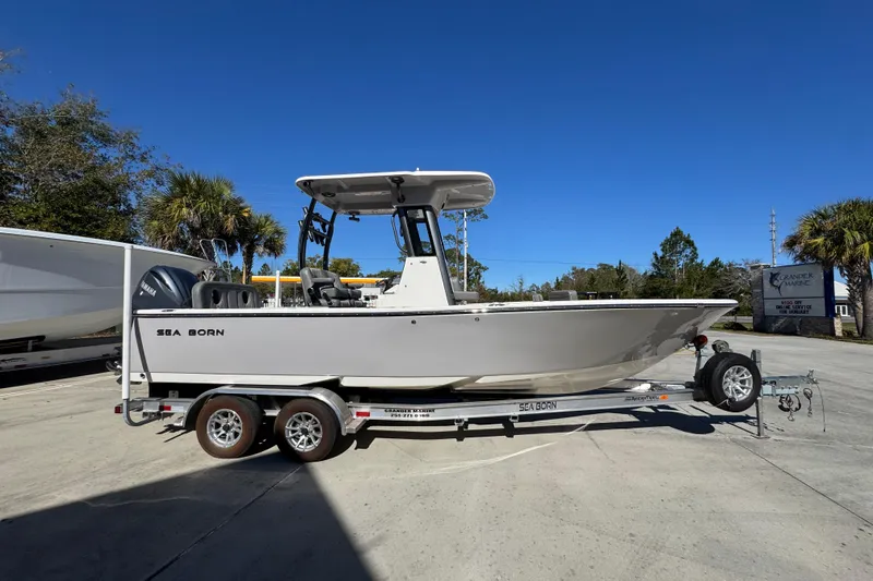Slide: The Image of 2026 Sea Born LX24 Center Console boat on trailer under clear blue sky. - 9