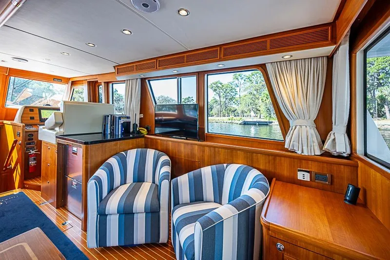 Slide: The Image of Luxurious interior of 2013 Grand Banks 43 Europa yacht with striped chairs and scenic window view. - 31