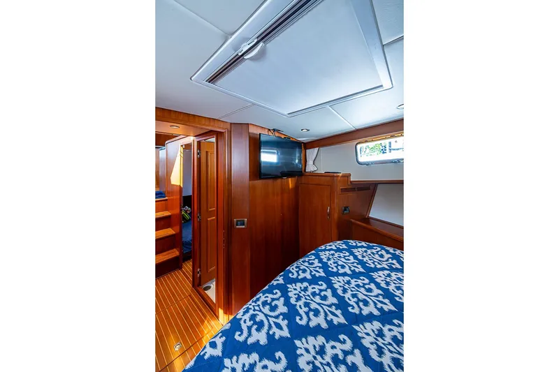 Slide: The Image of Luxurious cabin interior of 2013 Grand Banks 43 Europa yacht with wood finish and patterned bedding. - 45